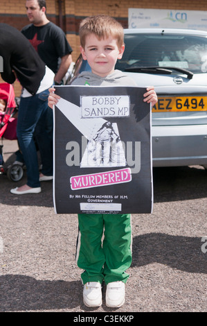 Boy est titulaire d'une affiche qui prétend Bobby Sands a été assassiné par le gouvernement britannique Banque D'Images