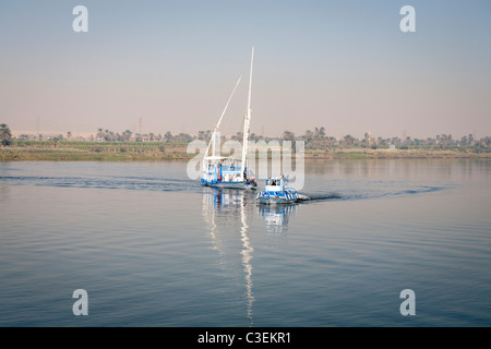 Un dahabiya remorqué par les petites embarcations sur le nil en eau calme, de l'Égypte, l'Afrique Banque D'Images