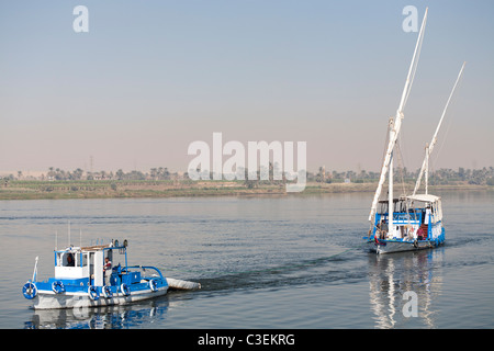 Un dahabiya remorqué par les petites embarcations à son amarrage sur les rives du Nil en eau calme, de l'Égypte, l'Afrique Banque D'Images