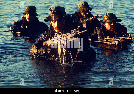 Les membres de l'équipe de l'US Navy SEAL émergent de l'eau au cours de la formation de guerre tactique. Banque D'Images