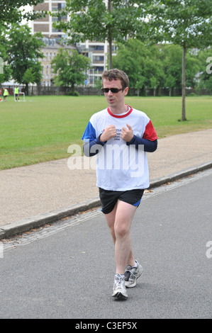 L'homme en jogging lunettes nerdy jogger dans Finsbury Park, Londres garder la forme meilleure course course concurrentielle idéal olympique Banque D'Images