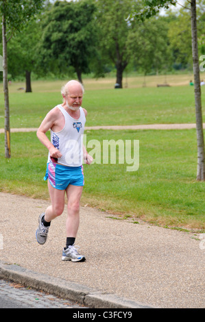 Vieil homme Senior citizen pensionné Runner exécutant keeping fit à Finsbury Park, Londres Banque D'Images