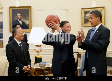 Le vice-Premier ministre chinois Wang Qishan, centre, tient le basket-ball qui lui ont été données par le président Barack Obama après leur Oval Banque D'Images