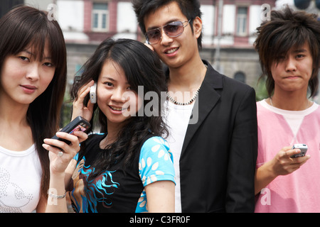 Amis chinois la messagerie texte et de parler sur les téléphones cellulaires Banque D'Images