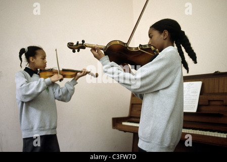 Deux filles de l'école secondaire à jouer du violon dans la classe de musique Banque D'Images