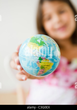 Petites Hispanic girl holding globe Banque D'Images