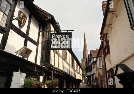 Church Lane Ledbury, Prince de Galles enseigne de pub et clocher d'église en arrière-plan. Herefordshire, Angleterre, RU Banque D'Images