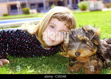 Pet dog et petite fille portrait sur jardin herbe park yorkshire terrier Banque D'Images