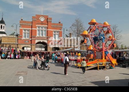 Une petite roue de Ferris ride dans un petit marché, avec l'Arsenal Royal, Woolwich Gatehouse derrière centre ville, East London, UK. Banque D'Images