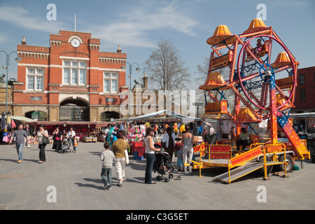 Une petite roue de Ferris ride dans un petit marché, avec l'Arsenal Royal, Woolwich Gatehouse derrière centre ville, East London, UK. Banque D'Images