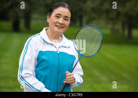 Senior Woman Holding Badminton Racket dans un parc Banque D'Images