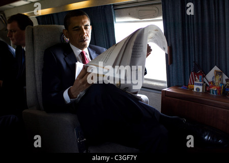 Le président Barack Obama se lit le journal du matin à bord de l'un en route vers la US Naval Academy début Banque D'Images