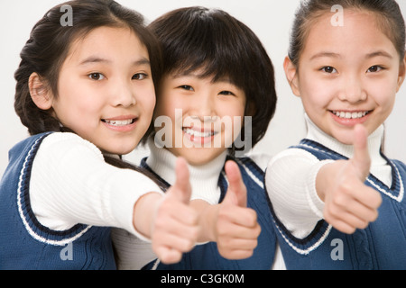 Les élèves giving thumbs-up en classe Banque D'Images