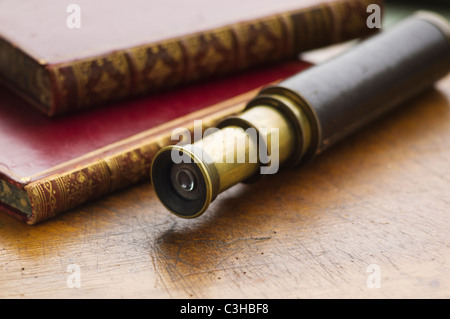 Close up de livres anciens et d'un télescope Banque D'Images