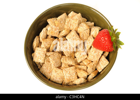 Bol de mini-shredded wheat surmontée d'une fraise. Banque D'Images