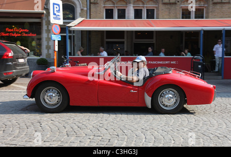 Voiture de sport rouge en voiture à travers Ypres, Belgique. Banque D'Images