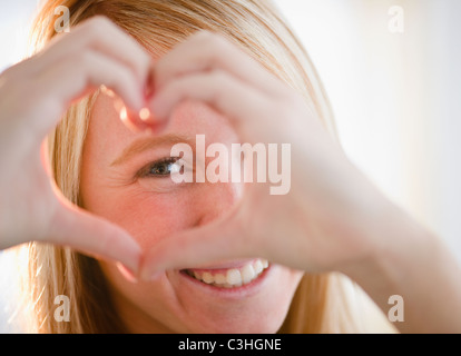 Woman making heart shape avec les doigts Banque D'Images