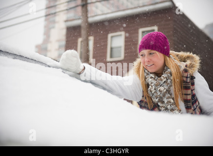 Femme enlever la neige du pare-brise Banque D'Images