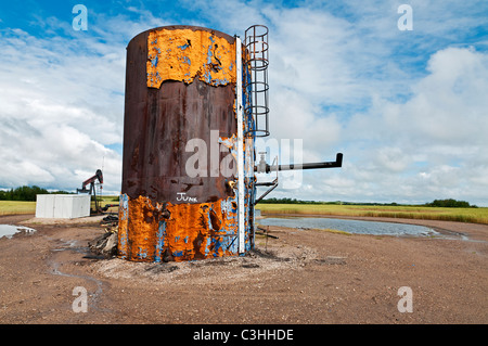 Paysage industriel : la désactivation du réservoir de stockage de pétrole brut se trouve au milieu d'un champ de céréales, de la Saskatchewan, Canada. Banque D'Images