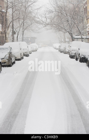 USA, New York City, snowy street avec des rangées de voitures en stationnement Banque D'Images