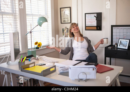 Woman holding, tasse de thé, avec les bras tendus Banque D'Images