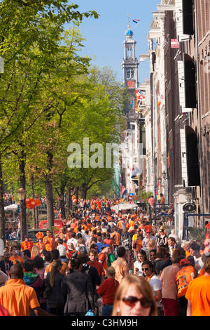 La fête du Roi Kingsday Kings Day Amsterdam foule sur le Canal Prinsengracht. Sous la Westertoren, icône de la ville. Banque D'Images