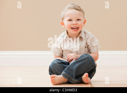 Portrait of young boy (2-3) sitting cross-legged Banque D'Images