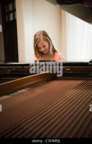 Girl (8-9) en jouant sur grand piano Banque D'Images