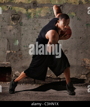 L'homme jouant au basket-ball en face de wall Banque D'Images