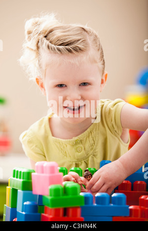 Portrait of smiling girl (2-3) en jouant avec des blocs colorés Banque D'Images