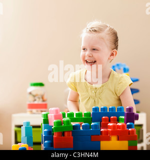 Smiling girl (2-3) en jouant avec des blocs colorés Banque D'Images