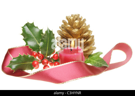 Décoration de Noël avec le houx, le lierre, Golden Pine Cone et une bougie allumée entourée par un ruban rouge bordé d'or Banque D'Images