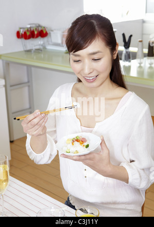 Young woman eating chirashi sushi Banque D'Images