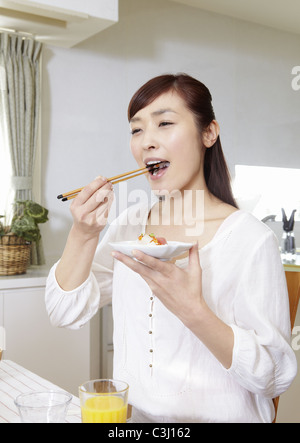 Young woman eating chirashi sushi Banque D'Images