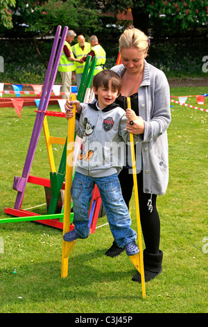 Jeune garçon essayant de marcher sur des échasses à un atelier cirque jour Banque D'Images