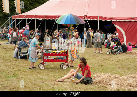 Une femme est assise sur l'herbe, devant le chapiteau tente au Port Eliot Literary Festival St allemands Cornwall Banque D'Images