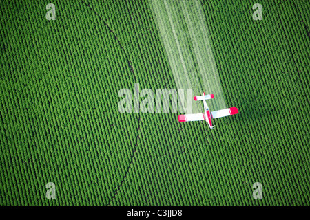 Une vue de dessus d'une culture duster spraying green terres agricoles. Banque D'Images