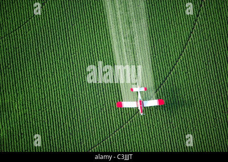 Une vue de dessus d'une culture duster spraying green terres agricoles. Banque D'Images