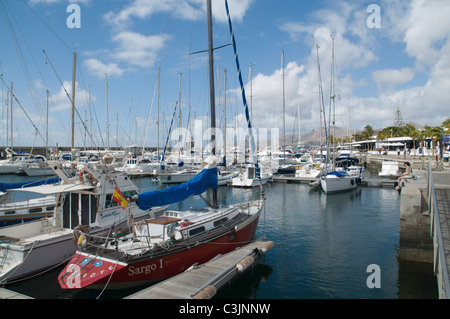 Dh Puerto Calero Marina Puerto Calero Lanzarote Couple sitting on yacht à quai dans le port de plaisance en bateau de la jetée Banque D'Images