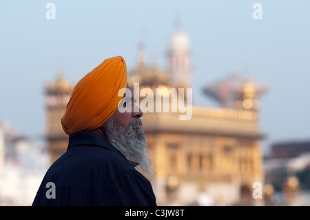 L'homme indien priant autour de l'étang de la Golden Temple d'Amritsar. Banque D'Images
