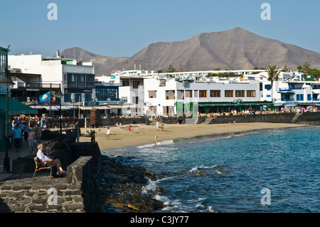 Dh Beach Playa Blanca Lanzarote homme assis sur le banc de la promenade du front de mer et de vacances ville Banque D'Images
