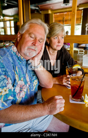 Un couple d'âge moyen semblait indifférent à l'ensemble plus de thés ensemble dans un Long Beach, CA, restaurant. MODEL