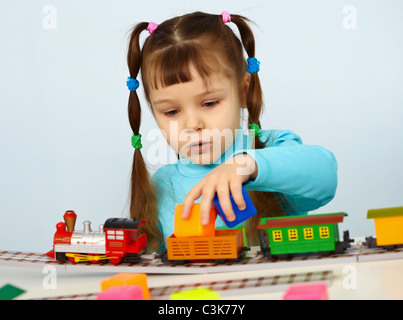 La petite fille d'âge préscolaire à jouer avec un jouet railway Banque D'Images