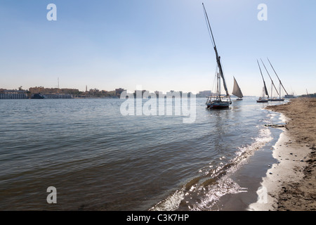 Felouque voile et amarré sur le Nil plage au coucher du soleil, Luxor, Egypte, Afrique du Nord Banque D'Images