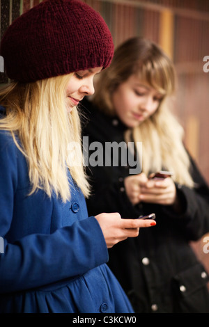 Deux adolescentes à l'aide de téléphones mobiles Banque D'Images