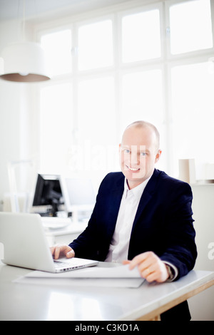 Man working in office, smiling Banque D'Images