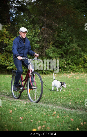 Senior man holding à vélo avec plomb chien Banque D'Images