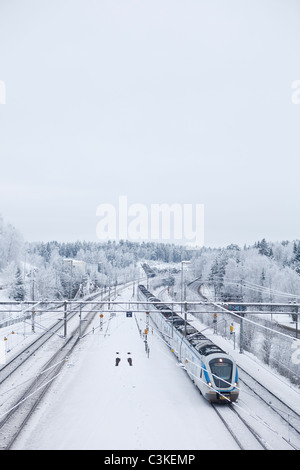 Train de voyageurs sur la voie de chemin de fer en hiver, elevated view Banque D'Images