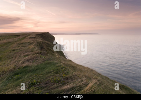 Magnifique coucher de soleil rouge au-dessus de Filey Brigg - coucher de soleil sur le sentier côtier de falaise, hautes falaises de grès et mer calme - côte du Yorkshire du Nord, Angleterre, Royaume-Uni. Banque D'Images