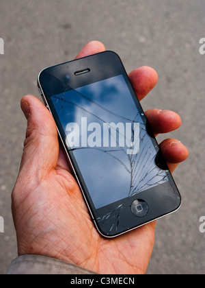Verre fissuré d'un iPhone 4 dans la paume de la main Banque D'Images